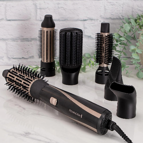 Remington hair styling tool with attachments on a marble surface with a white brick wall background.