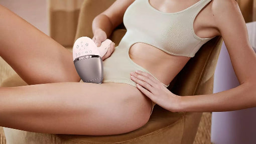 Person using a handheld device on their leg, possibly for skincare or hair removal.