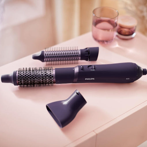 A Philips 3000 Series Air Styler with various attachments laid out on a table, showcasing the product's capabilities for hair styling.
