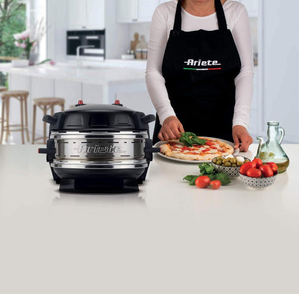 Person preparing pizza with Ariete kitchen appliance in a modern kitchen.